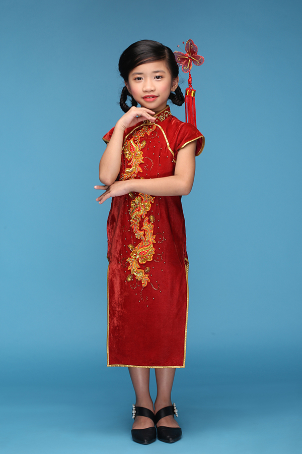 Mẫu áo sườn xám tông màu đỏ tươi mang đặc trưng không khí lễ hội của người Hoa cũng được chọn cho bé Nguyễn Phúc Mi Lan.