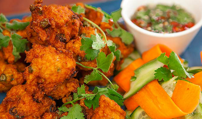 Chả cá kiểu Thái được rán ngay tại quầy, trong một chiếc chảo lớn luôn xèo xèo mỡ, mùi thơm nghi ngút chắc chắn sẽ thu hút khách qua đường. Từng miếng chả cá dai, thịt cá ngọt quyện lẫn với vị thơm của lá chanh, mùi tàu và đậu, được chấm kèm với tương ớt chua ngọt, cay cay rất thú vị.