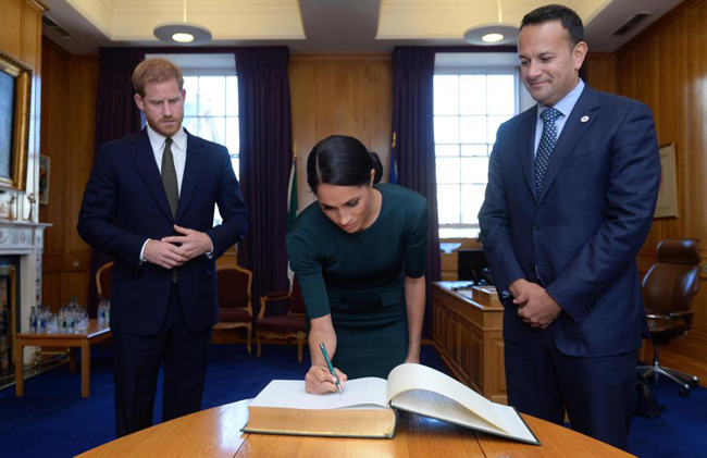 Meghan viết bằng tay trái trong chuyến công du Ireland cùng chồng hồi tháng 7. Ảnh: PA.